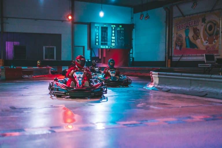 Drei Karts mit Fahrer auf der Strecke in einer Kurve.