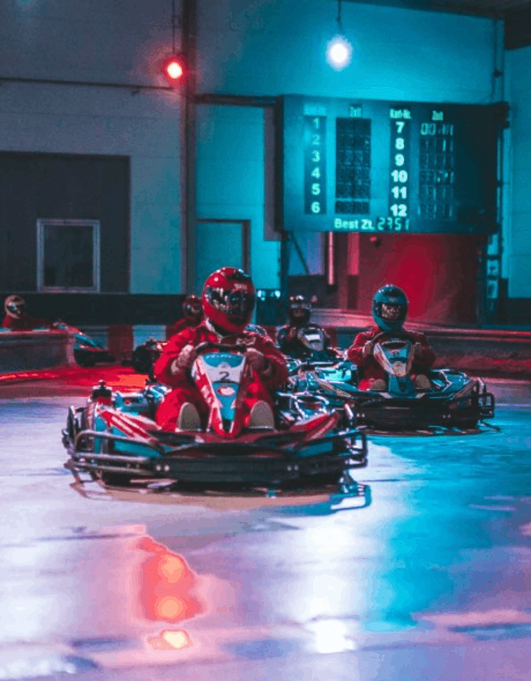 Zwei Karts mit Fahrer auf der Strecke in einer Kurve.