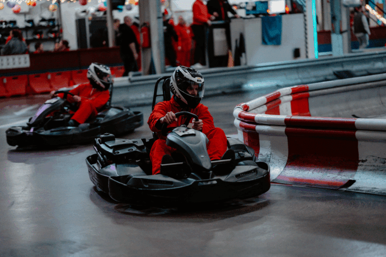 Zwei Karts fahren dicht hintereinander im Wettkampf auf der Rennbahn des Kartcenter Cologne beim Kartfahren Köln.
